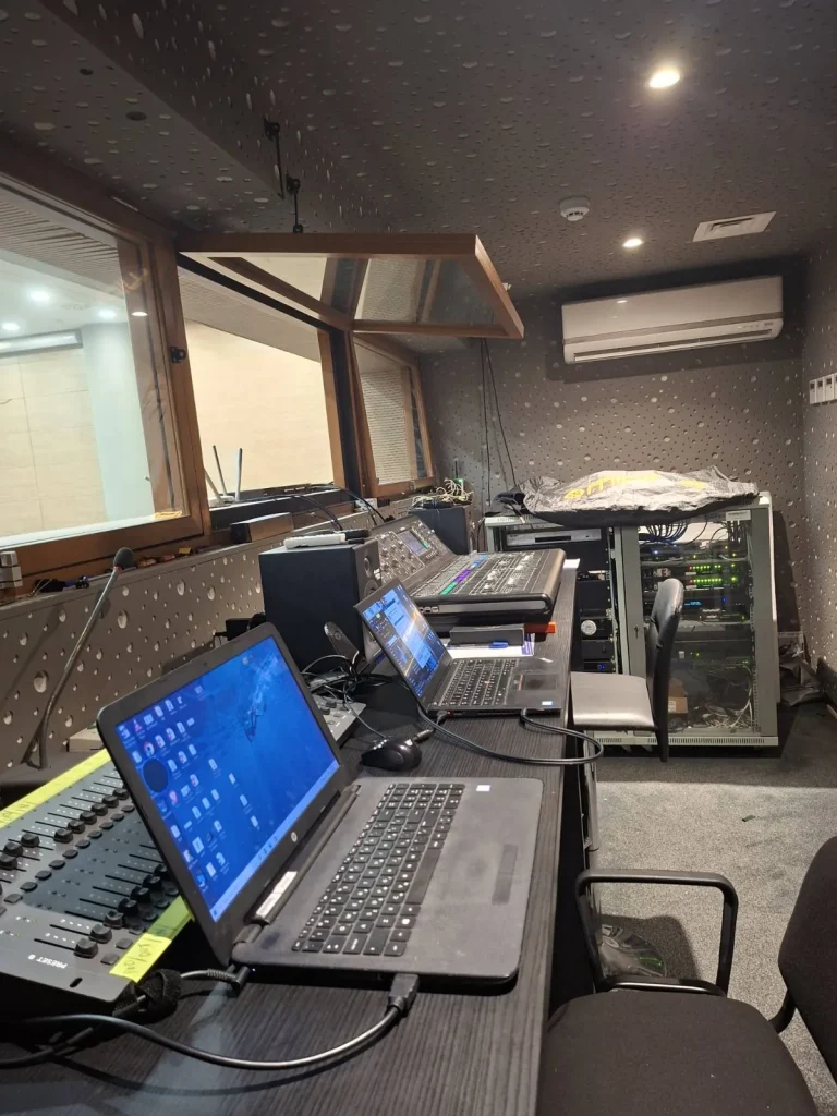POED conference hall audio control room with digital mixing console and equipment racks